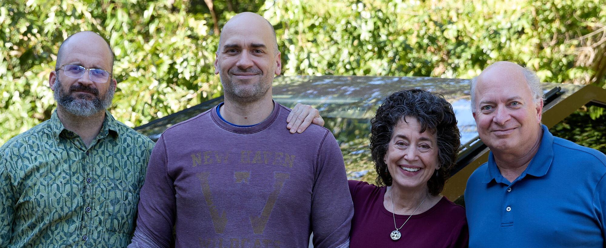 Jason Frailey, Derek Scherer, Julia Scherer, and Ed Scherer standing together outdoors, smiling.